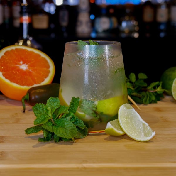 Refreshing mojito with lime, mint, and a jalapeño on a wooden surface at Boardwalk Beer Garden.